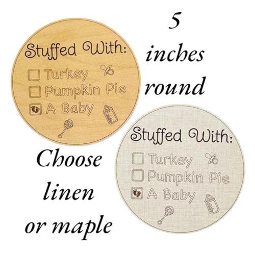 Expecting pregnancy announcement sign with a fall or Thanksgiving theme. Turkey, pumpkin pie, or a baby? Five inches round with engraved details. Linen or maple wood color options. From Art by Iceberg, a female-owned small business in Colorado.