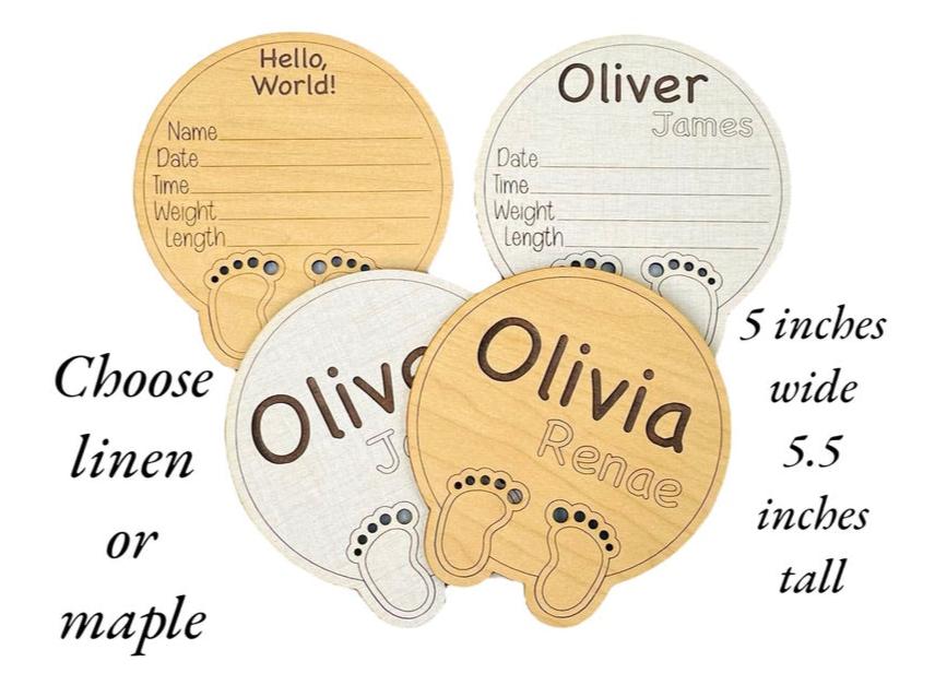 Birth announcement round signs shown against a white background in the two color options - linen and maple wood. Engraved name and birth stat area. Cute baby feet and toes laser-cut and laser-engraved at the bottom. Ideal baby shower gift item!