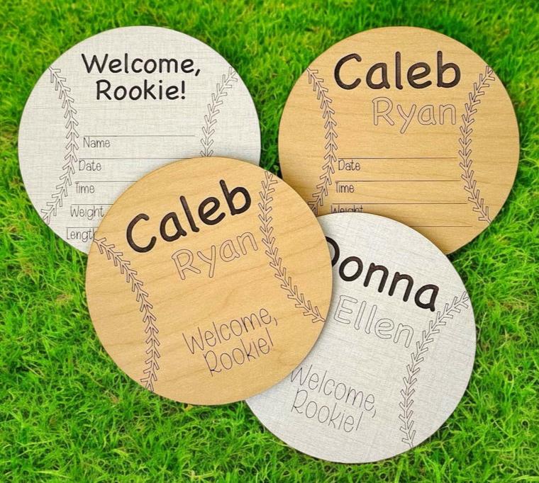 Softball or baseball shaped and themed baby birth announcement wooden round. Engraved stitches and first and middle baby name. Welcome rookie! Area for birth stats below - write in with a pen or marker. From Art by Iceberg.